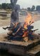 Nepal: A body on a funeral pyre at a cremation, Pashupatinath, Kathmandu
